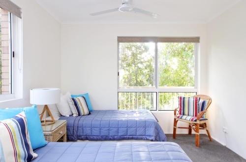努萨角Serenity Apartments Noosa的一间卧室设有两张床和窗户。