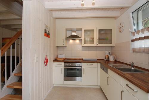 巴贝Strandpark Baabe Haus 224的厨房配有白色橱柜和水槽