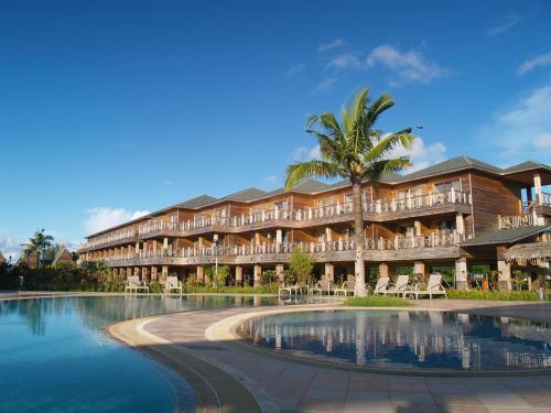 科罗尔帕劳天堂岛渡假村俱乐部的一座带游泳池的度假村,位于一座建筑前