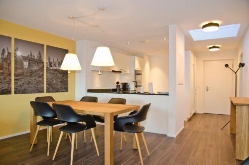 因特拉肯Apartment Silberdistel - GriwaRent AG的用餐室以及带木桌和椅子的厨房