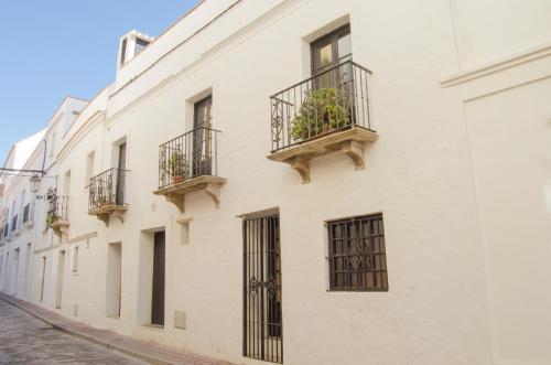 塔里法Apartamentos Tarifa Castillo的白色的建筑,在街上设有阳台