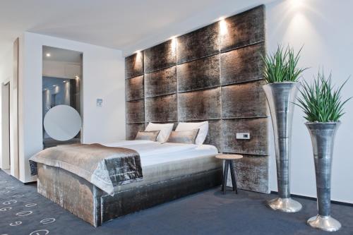 卢布尔雅那G设计酒店的一间卧室设有一张大床和木墙