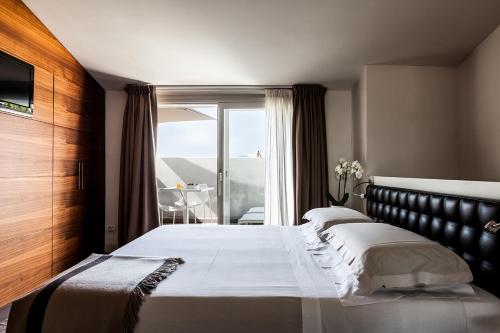 阿西西嫩阿西斯瑞雷斯温泉博物馆酒店的一间带大床的卧室和一个阳台