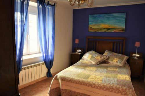 Montemayor de PilillaCasa Rural El Camino的一间卧室配有一张蓝色墙壁的床和一扇窗户