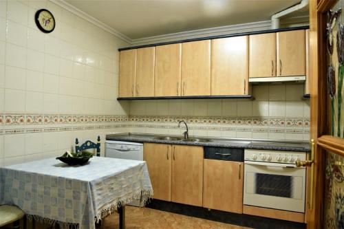 Montemayor de PilillaCasa Rural El Camino的厨房配有木制橱柜和带水槽的桌子。