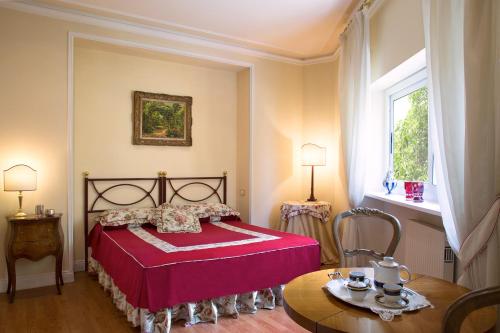 罗马奥瑞尼套房酒店的一间卧室配有红色的床和一张桌子