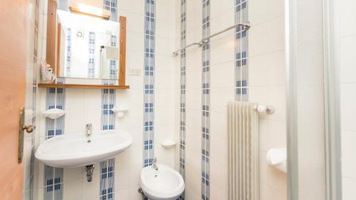 戴亚诺Hotel Garni Edy的一间带水槽和镜子的浴室