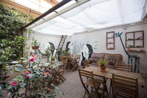 都灵Tomato Urban Retreat的一个带桌椅和植物的庭院