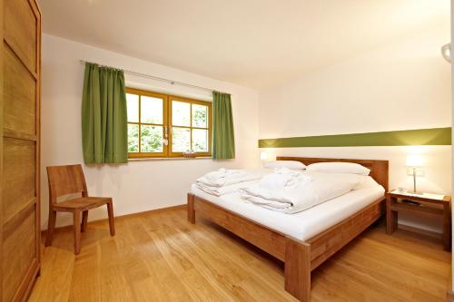 格赖瑙楚格峰公寓的卧室配有床、椅子和窗户。