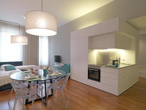 波尔图FLH New Oporto Apartments - Mouzinho的厨房以及带桌椅的起居室。
