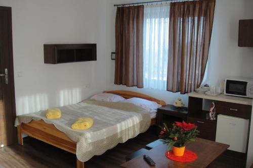 布科维纳-塔钱斯卡旺塔酒店的一间小卧室,配有一张床和一张桌子