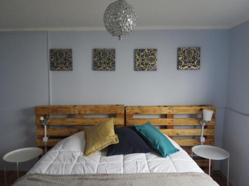 瓦尔帕莱索Mi Paz的卧室配有一张木床,墙上挂有四张照片