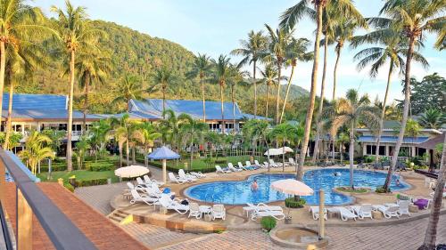 高兰Andaman Lanta Resort - SHA Extra Plus的一个带游泳池、椅子和棕榈树的度假村