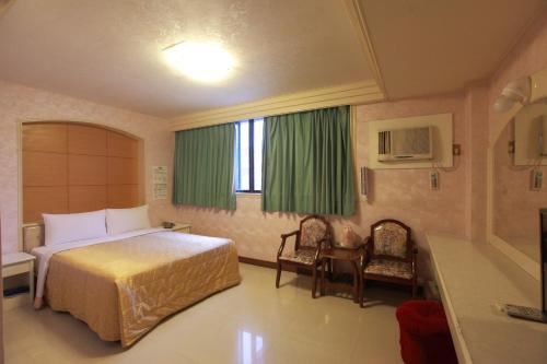 花莲市花莲永祺饭店 的酒店客房,配有一张床和两把椅子