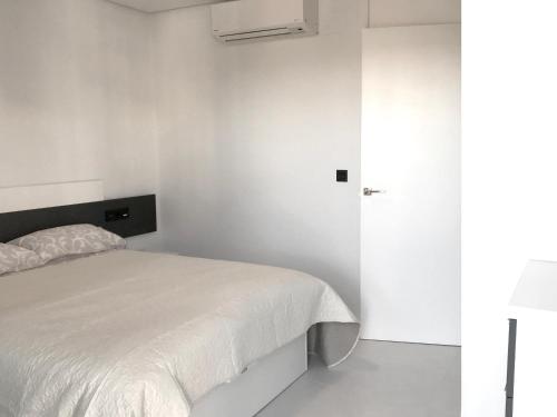 皮拉尔－德拉奥拉达达Bioko II Mil Palmeras的卧室配有白色的床和白色的墙壁