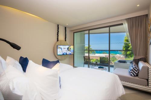 卡塔海滩The SIS Kata Resort - Adult Only的卧室设有白色的床和大窗户