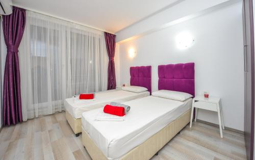 布加勒斯特Harmony Suites的紫色色调的客房内的两张床