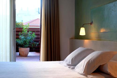 罗萨斯卡门酒店的一间卧室配有一张带灯和窗户的床