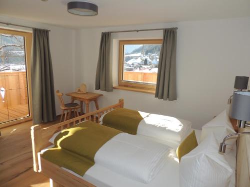 富尔普梅斯Buttererhof-Apartments的一间卧室设有两张床、一张桌子和一个窗口