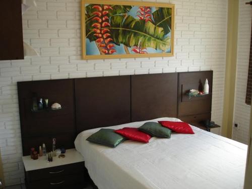因比图巴Pousada Cheiro De Mar的一间卧室配有红色和绿色枕头的床