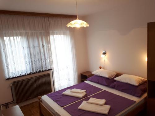 格拉博瓦茨Guest House Borić的一间卧室配有一张紫色床和毛巾