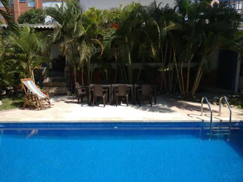 哥伦比亚港Hotel Boutique Casa Berastegui的一个带桌椅和棕榈树的游泳池