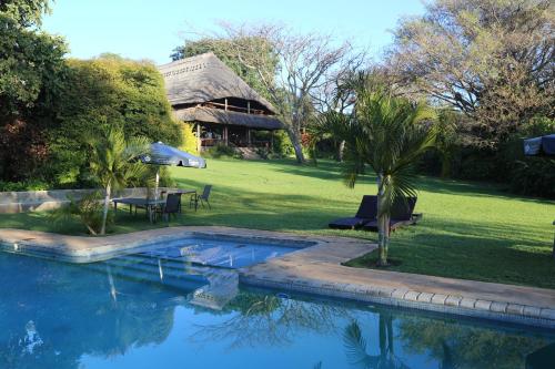 利隆圭Kumbali Country Lodge的庭院中带游泳池的房子