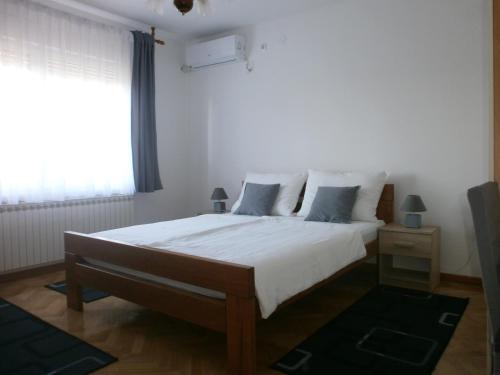 卡尔洛瓦茨House Bogović的一间卧室配有一张带白色床单的床和一扇窗户。