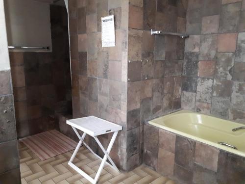 温特和克Puccini House的浴室设有浴缸和凳子。