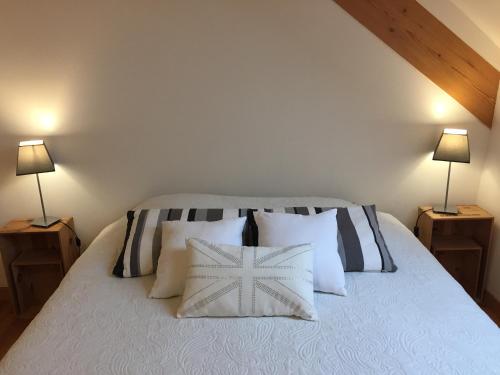 Abelcourt吕克瑟尔温泉公寓的一间卧室配有一张带枕头的床和两盏灯。