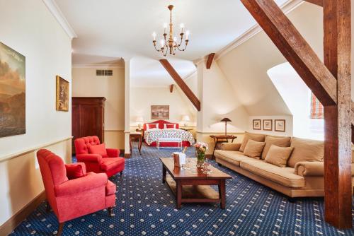 BeláHotel Château Bela的客厅配有红色椅子和沙发