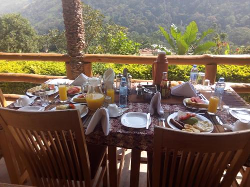 BuhomaBwindi Forest Lodge的餐桌,带食物和橙汁杯
