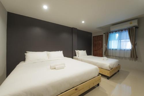 清迈庞萨克普拉西住宿加早餐旅馆的一间卧室配有两张带白色床单的床
