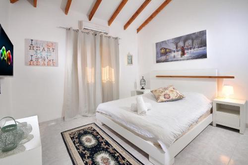 萨法德Family Villa的白色的卧室设有床和窗户