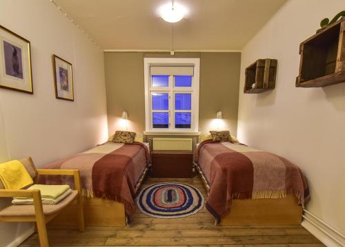 Djupavik迪居帕威客酒店的客房设有两张床和窗户。