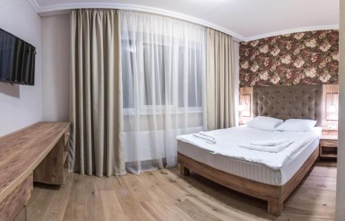 斯拉夫西克Рандеву的一间卧室设有一张床和一个大窗户