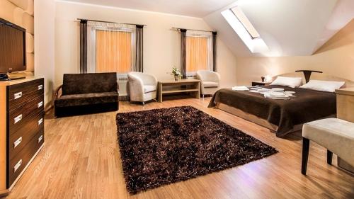 Głogów Małopolski翠兹科罗尼酒店的一间卧室配有一张床、一张沙发和一把椅子