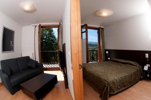 扎鲁亚斯塔莱门迪旅游公寓酒店的卧室配有床、椅子和窗户。