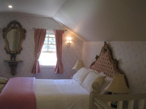 Kurrajong安妮小屋旅馆的一间卧室配有一张床、镜子和窗户