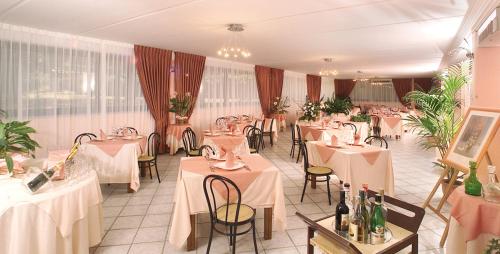 斯卡尔利诺兰琪酒店的餐厅配有桌椅和白色的桌布