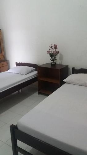 索龙彭金阿帕恩科菲亚度假屋的一间卧室配有两张床和一张鲜花桌