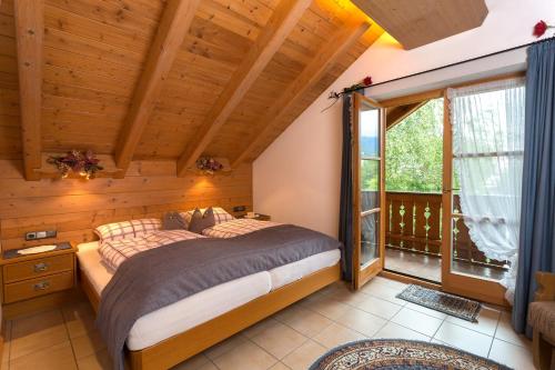 米滕瓦尔德费林豪瑟韦德菲尔斯酒店的一间卧室设有一张床和一个大窗户