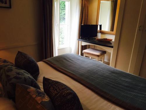 Bowland Bridge梅森阿尔姆斯住宿加早餐旅馆的一间卧室配有一张床和一张带镜子的书桌