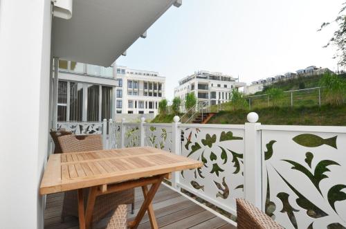 奥斯赛拜-塞林Villa "Johanna" Sellin - WG13 mit Kamin und zwei Balkonen的阳台配有木桌和椅子