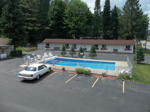 普莱西德湖凯瑞织豪斯汽车旅馆的停在游泳池旁的停车场的汽车