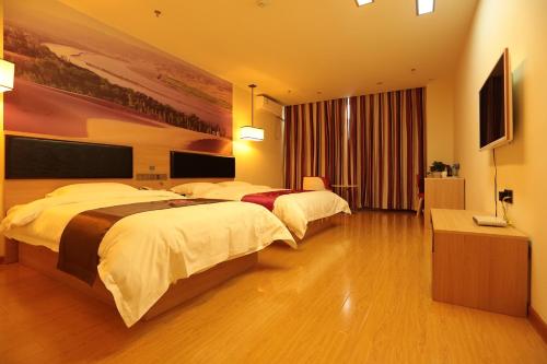 银川尚客优连锁宁夏银川西夏区同心路店的酒店客房设有两张床和电视。