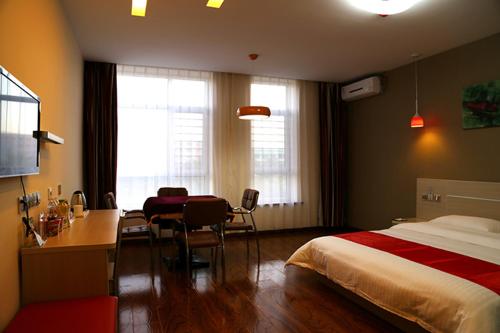 Yanjun尚客优连锁辽宁鞍山海城万达店的酒店客房配有一张床、一张书桌和一张书桌。