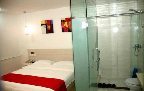 沧州尚客优连锁河北沧州解放西路店的浴室设有床铺和玻璃淋浴间。