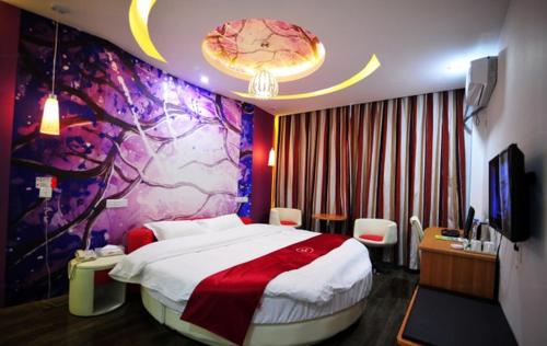 安顺尚客优连锁贵州安顺开发区西航路店的一间卧室设有一张大床和色彩缤纷的墙壁