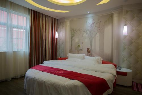 洛阳尚客优连锁河南洛阳西工区王城大道店的一间卧室配有一张大床,铺有红白毯子